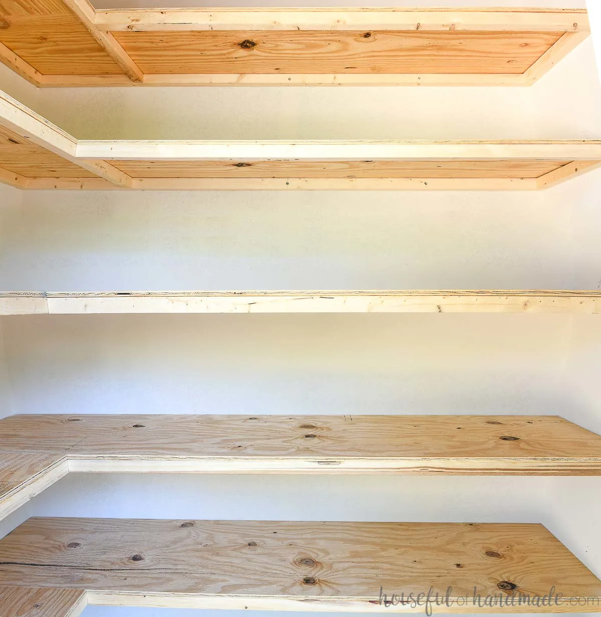 Close up of the budget DIY storage shelves with 2x2 frames and inexpensive plywood tops.