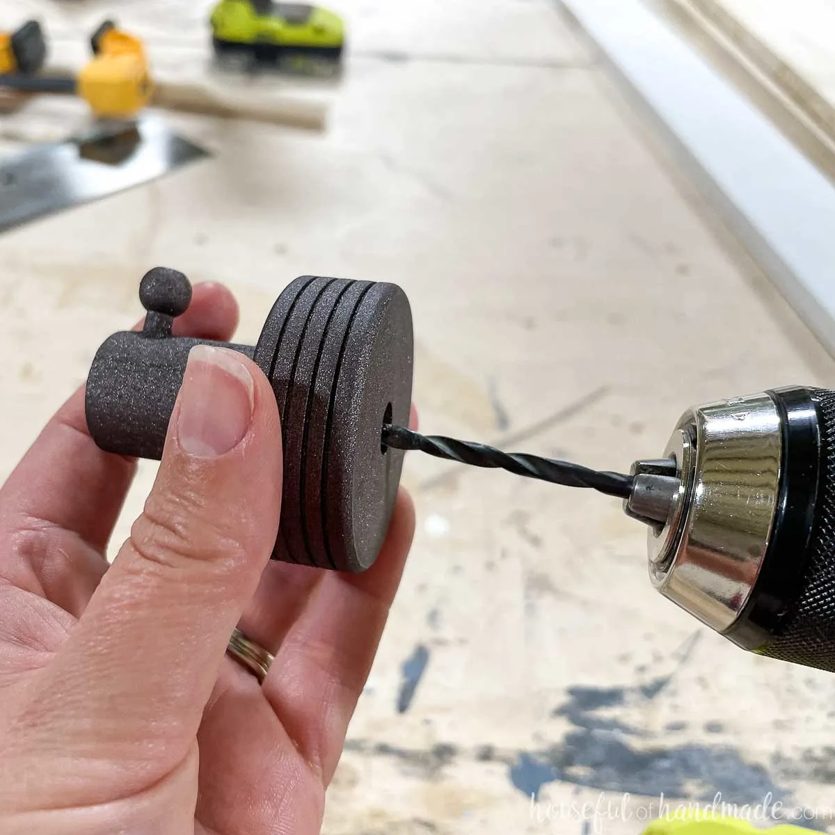 Drilling a hole into the back of the painted wall hook. 