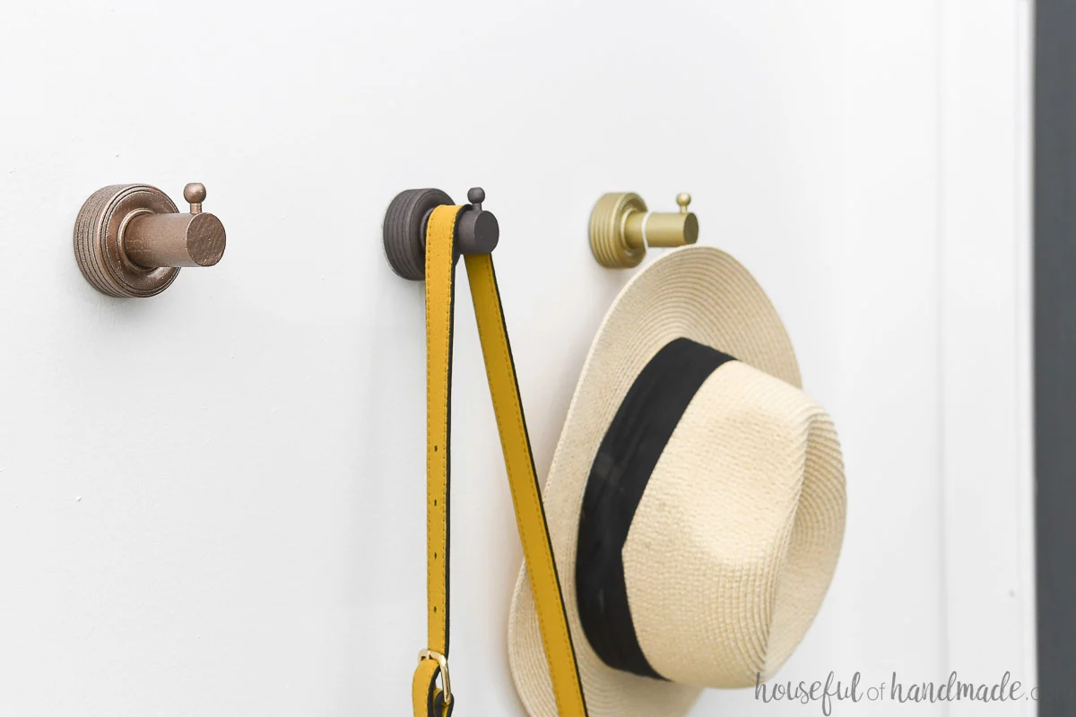 Three DIY wall hooks with things hanging on them. 