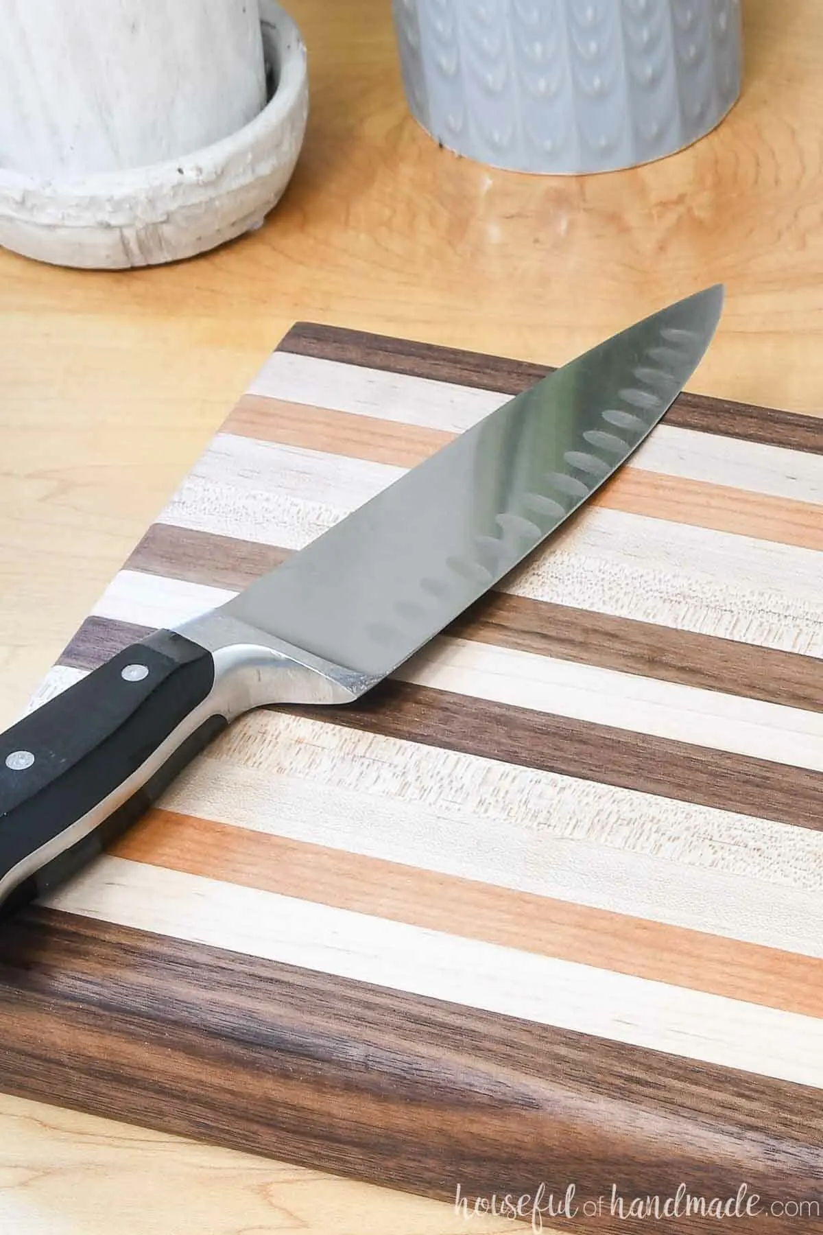 Close up of an edge grain cutting board made from 1x2 boards with walnut, maple and cherry boards. 