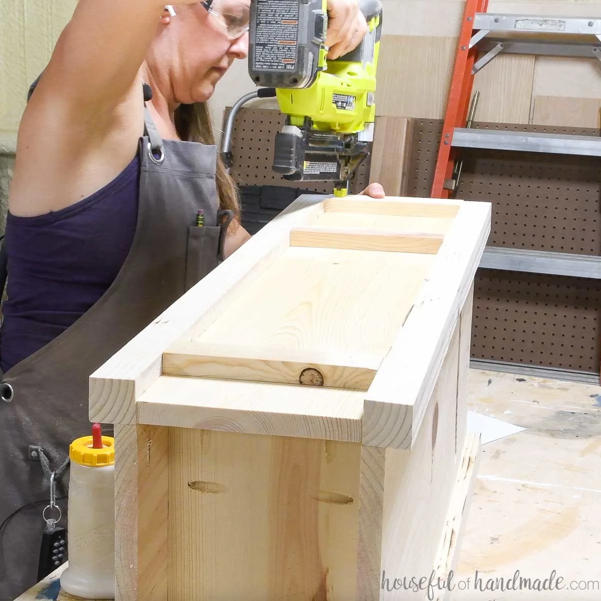 Attaching 1x2 trim to the side of the assembled mailbox body. 