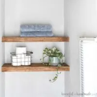 Easy DIY floating shelves stained medium brown in a nook.