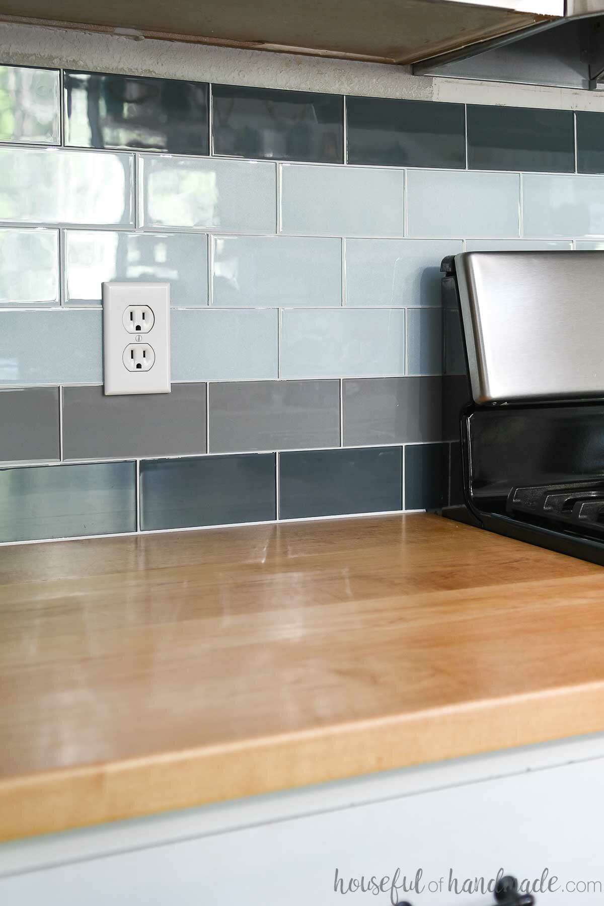 DIY tile backsplash over wood countertops next to a stove. 