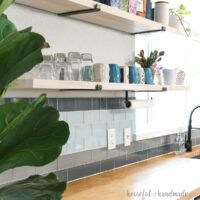 DIY tile backsplash over wood countertops and below open shelves.