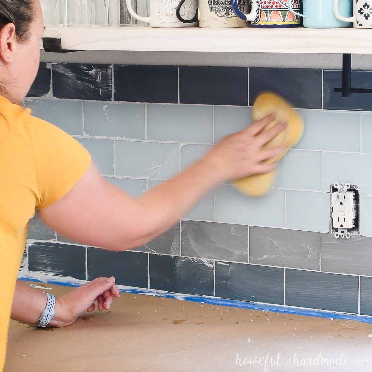 Finishing the grout with a damp yellow tile sponge. 