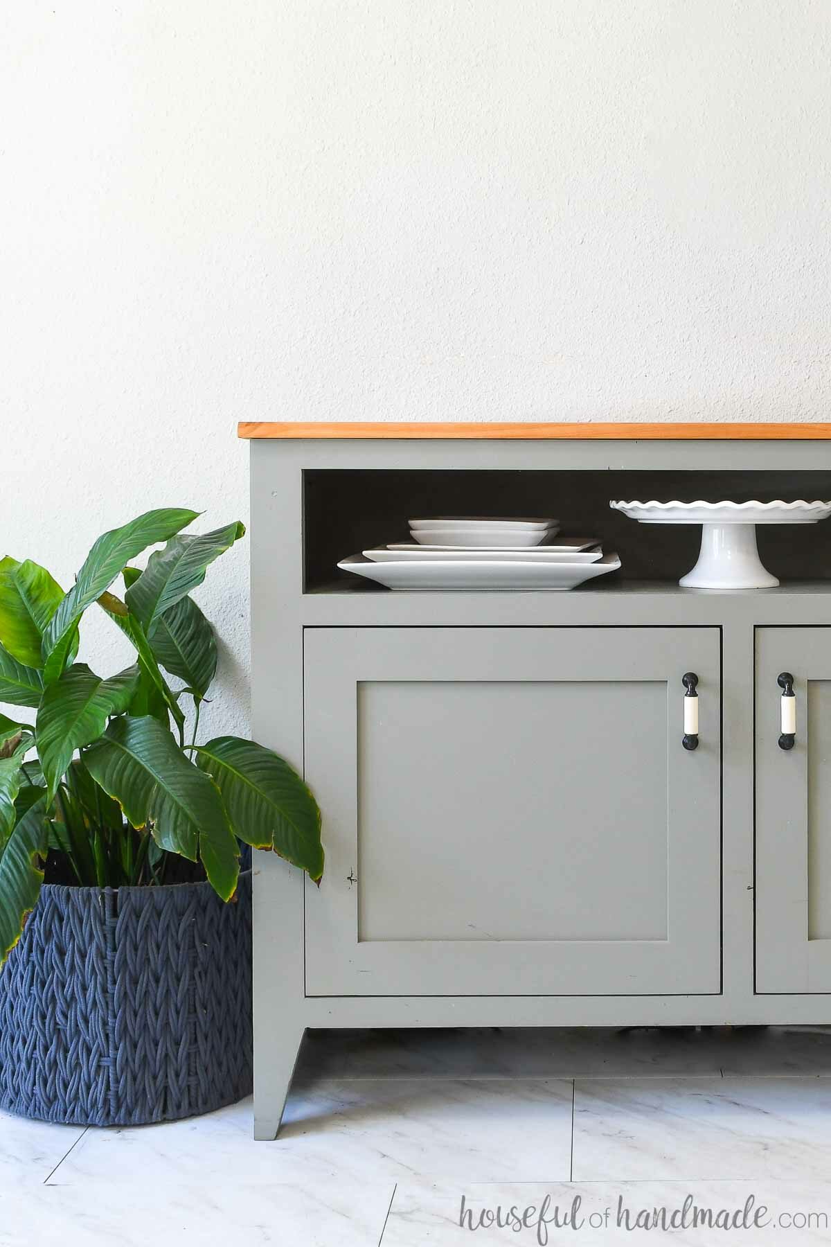 Medium green gray painted sideboard buffet table with shelf for platters and wood top.