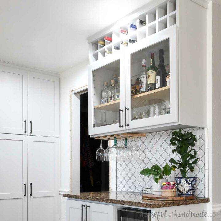 Dry bar in a kitchen with DIY glass cabinet doors on the wall cabinets.