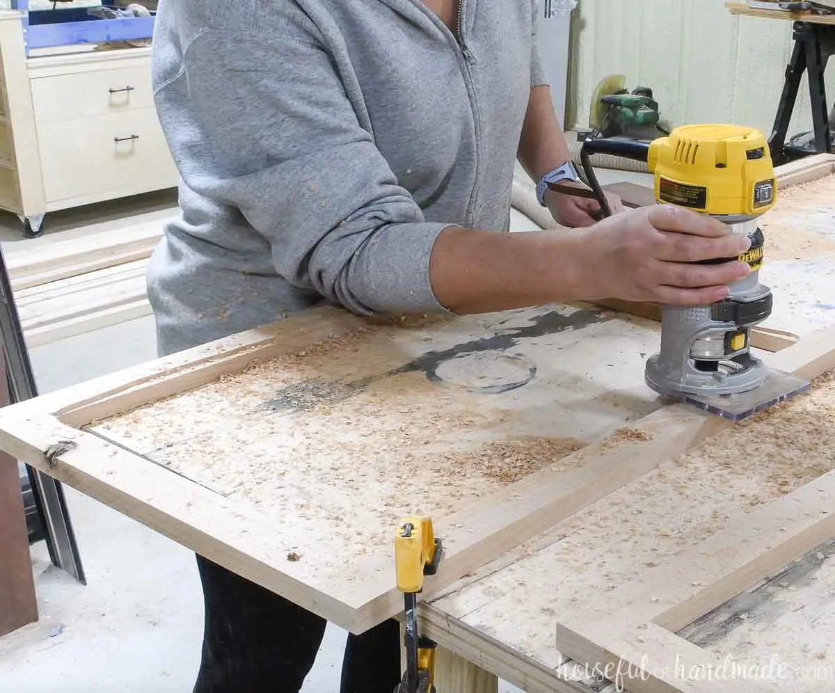 Using a ball-bearing router bit in a trim router to add a groove to the back of the door frame. 