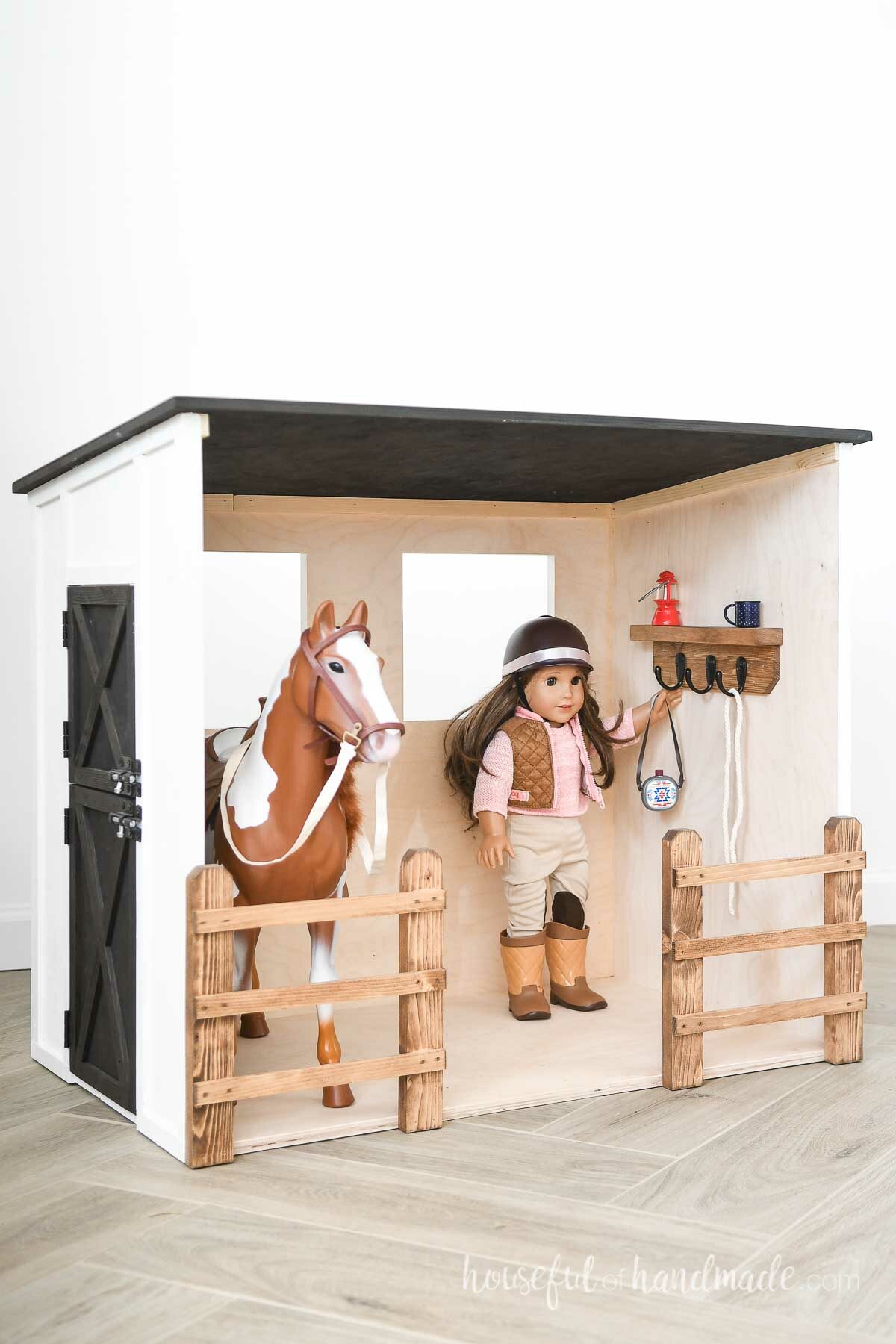 Black and white horse stable dollhouse with an American Girl doll and horse inside. 