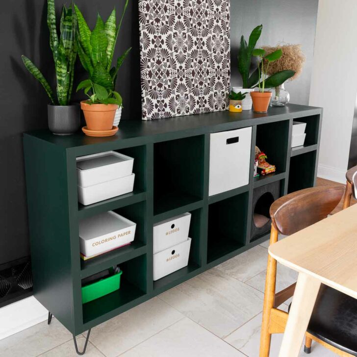 Modern cube storage unit with square cubbies and adjustable shelves on gold furniture feet.