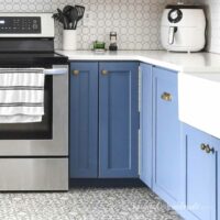 Blue base cabinets in a kitchen with a bifold corner cabinet in the corner.