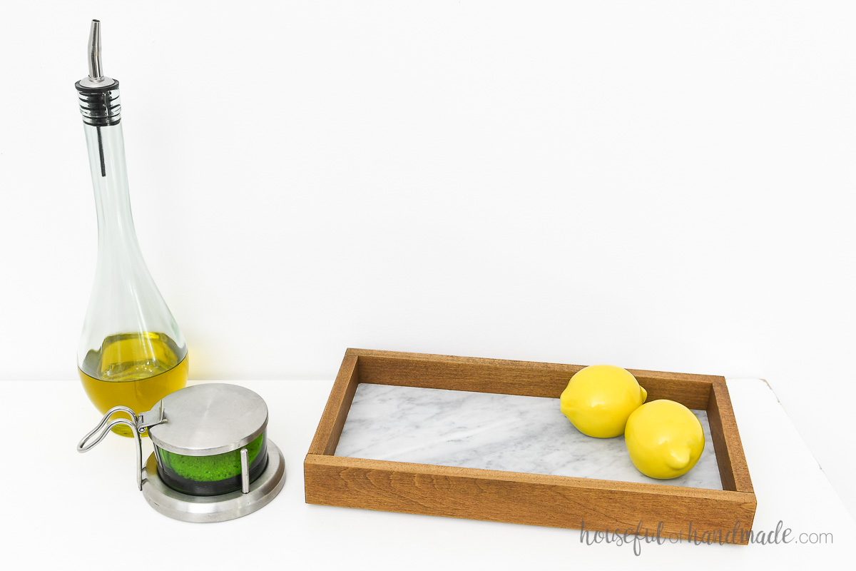DIY tray with a marble tile bottom organizing kitchen supplies. 
