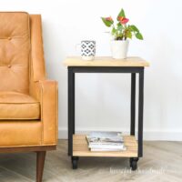 DIY side table with wheels and metal frame next to a chair.