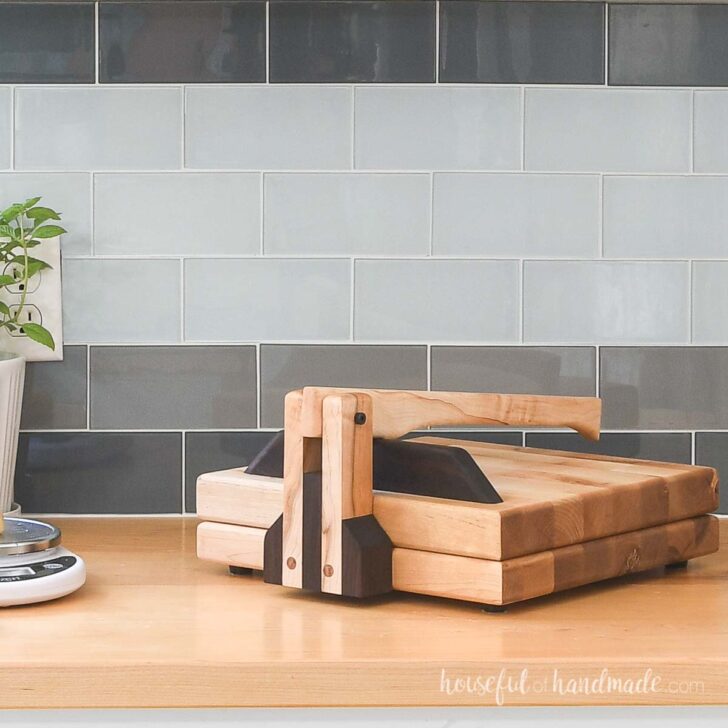 Large wood tortilla press with contrasting wood species on a wood countertop.