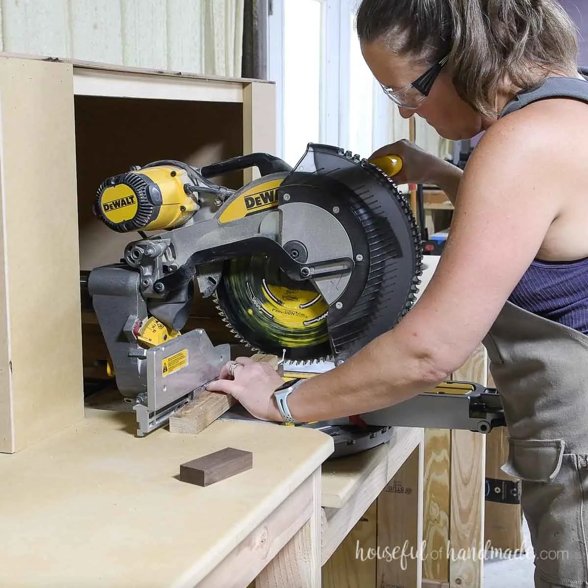 Using a scrap of wood to hold a small piece of wood while cutting it on a miter saw. 