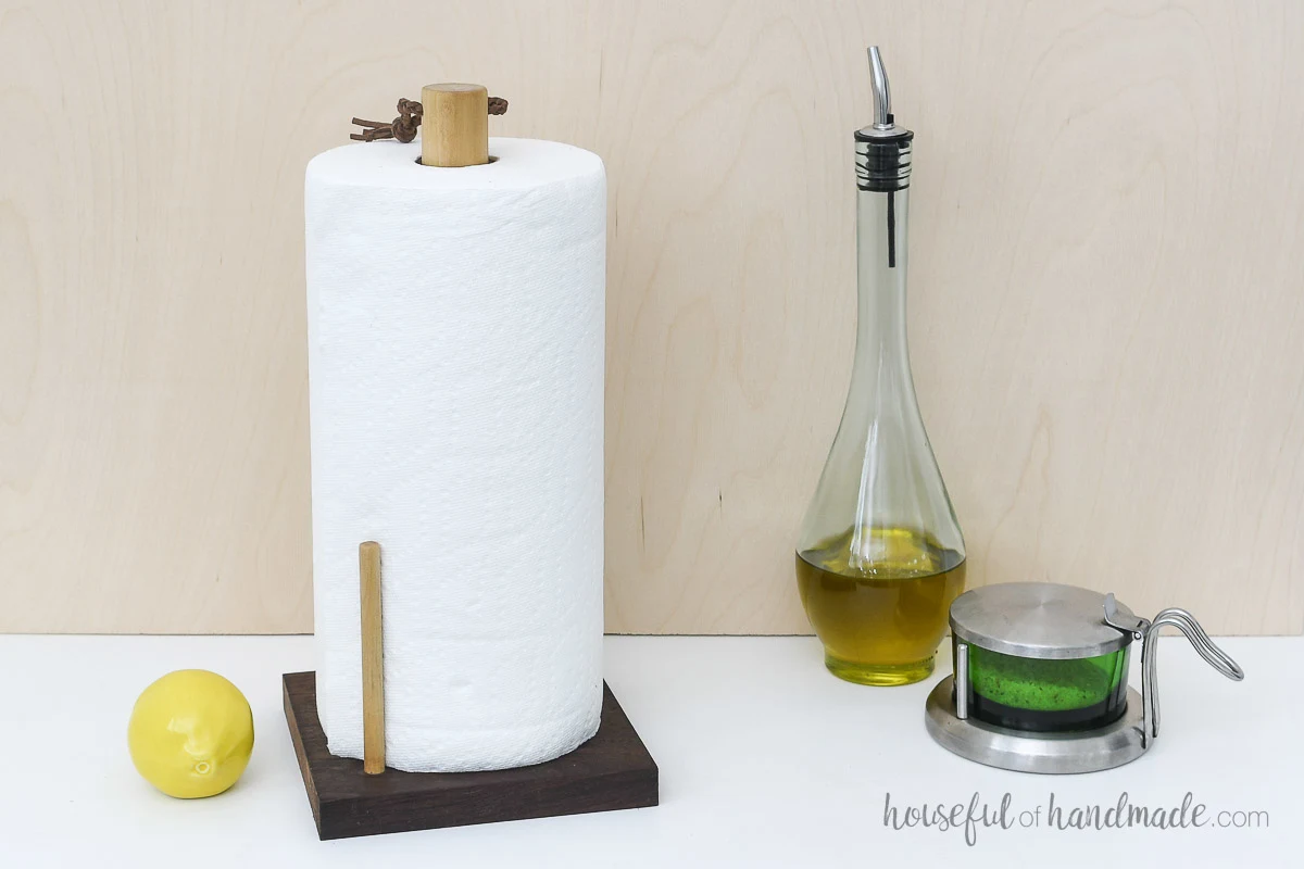 DIY vertical paper towel holder with extra dowel to hold paper towel roll in circle. 