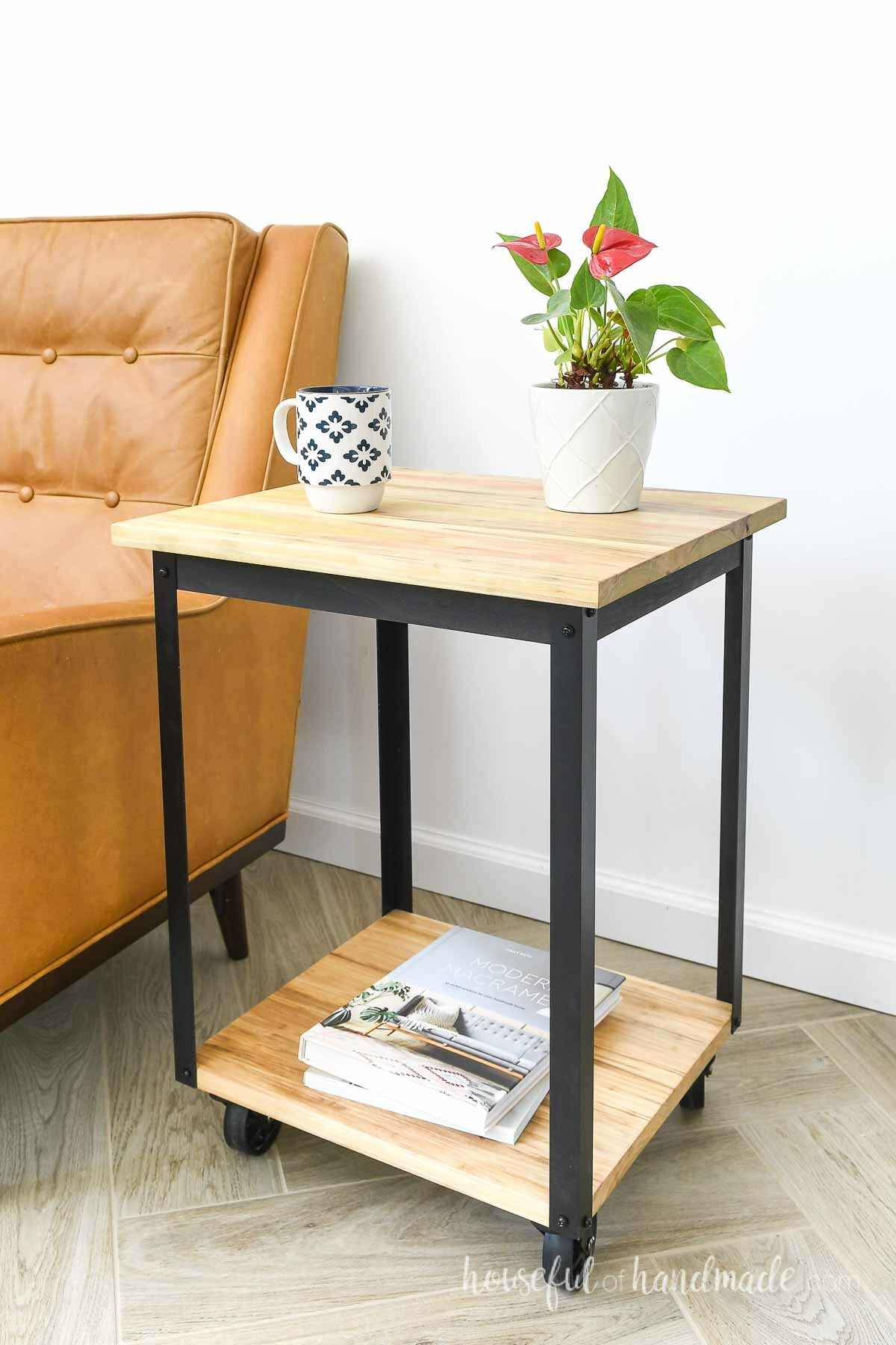 DIY end table on wheels next to a brown leather chair. 