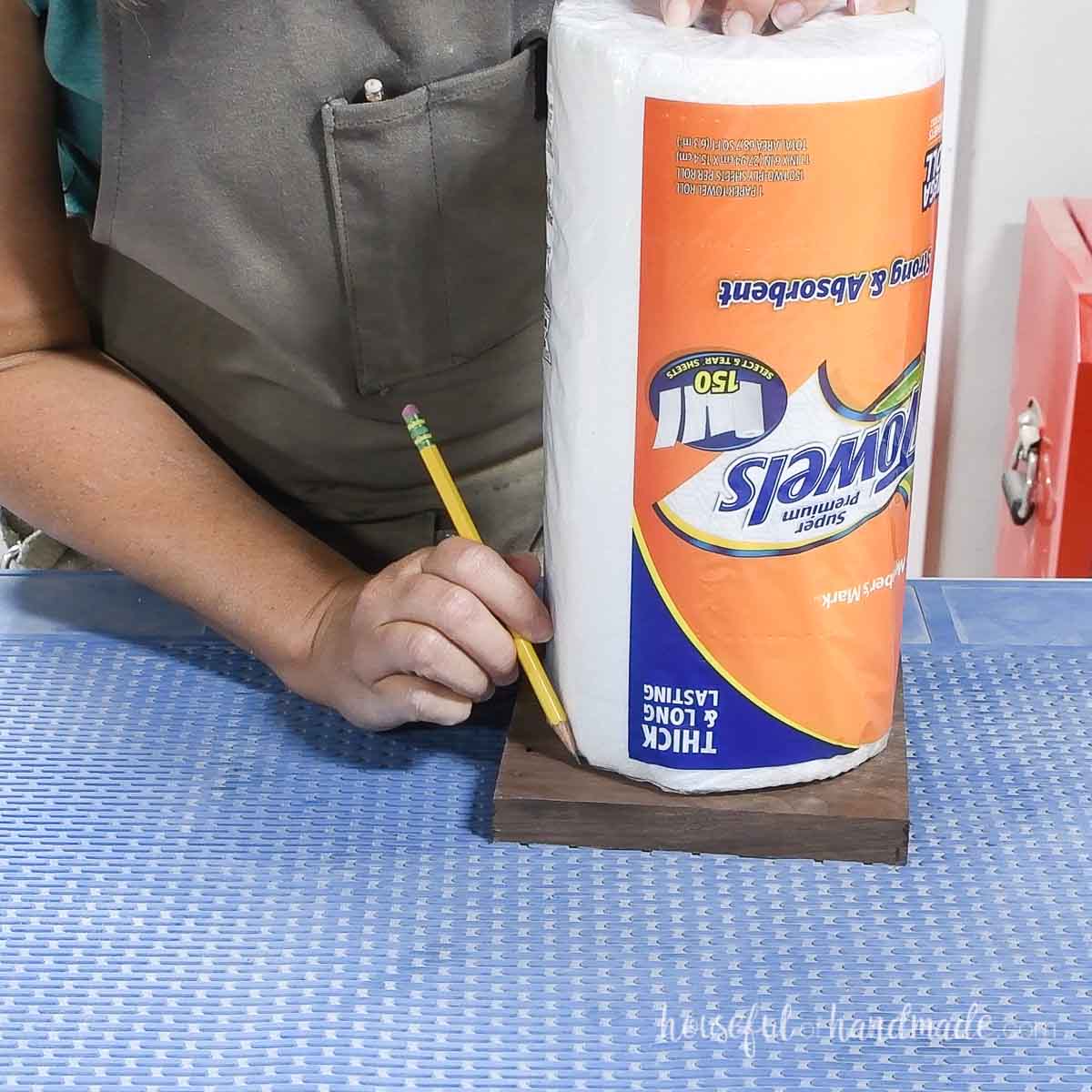 Drawing the edge of the paper towel roll onto the board.