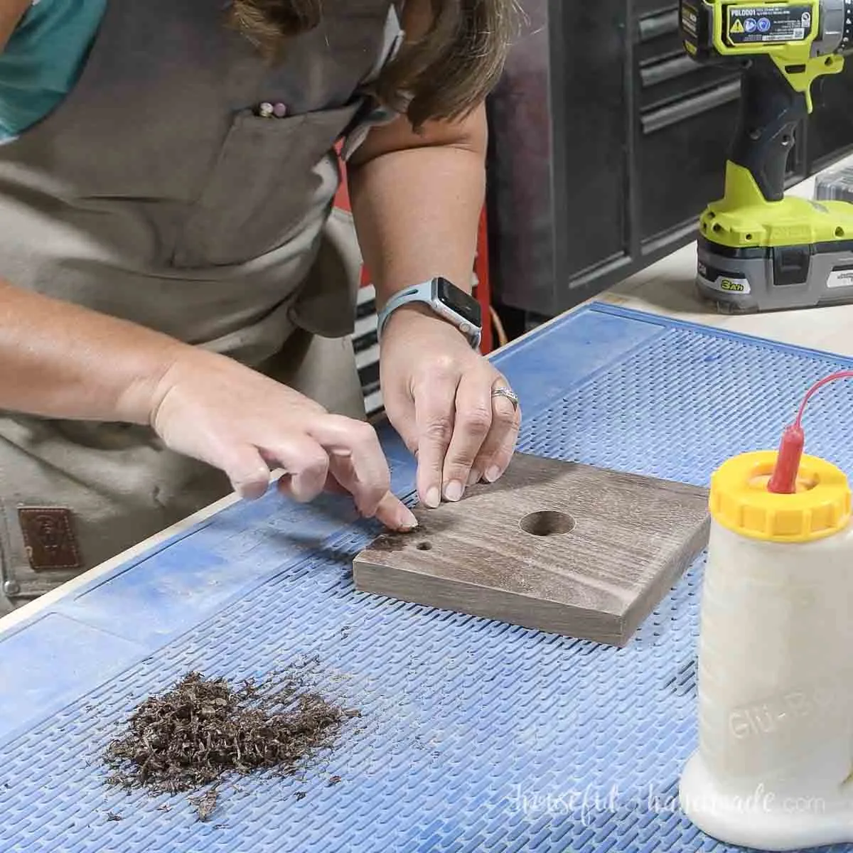 Using wood glue and sawdust to fill a hole in the wood.