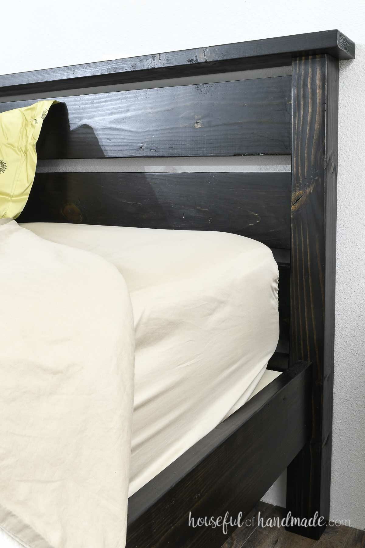Close up of the DIY bed with the side rails set in from the edge of the headboard. 