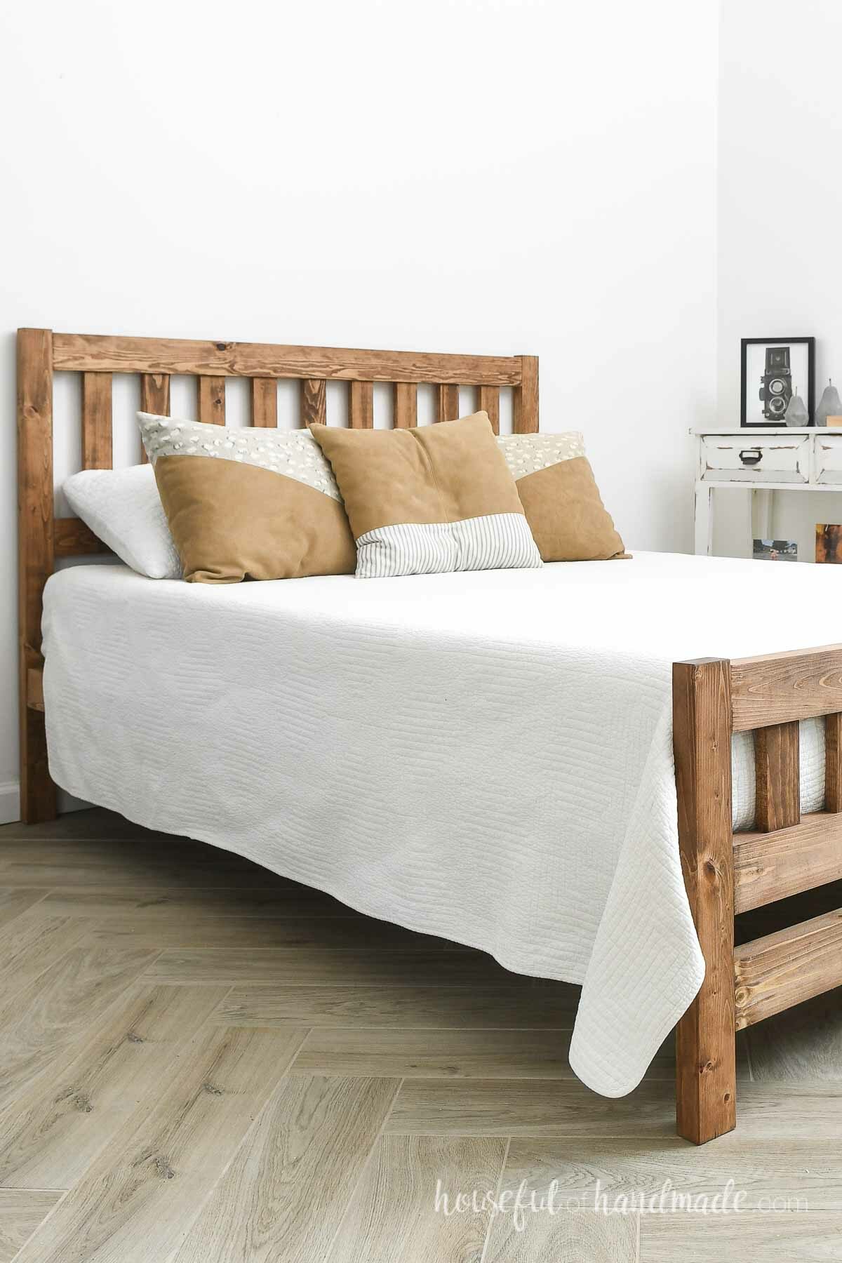 Beautiful mission style DIY bed with white comforter and leather pillows. 