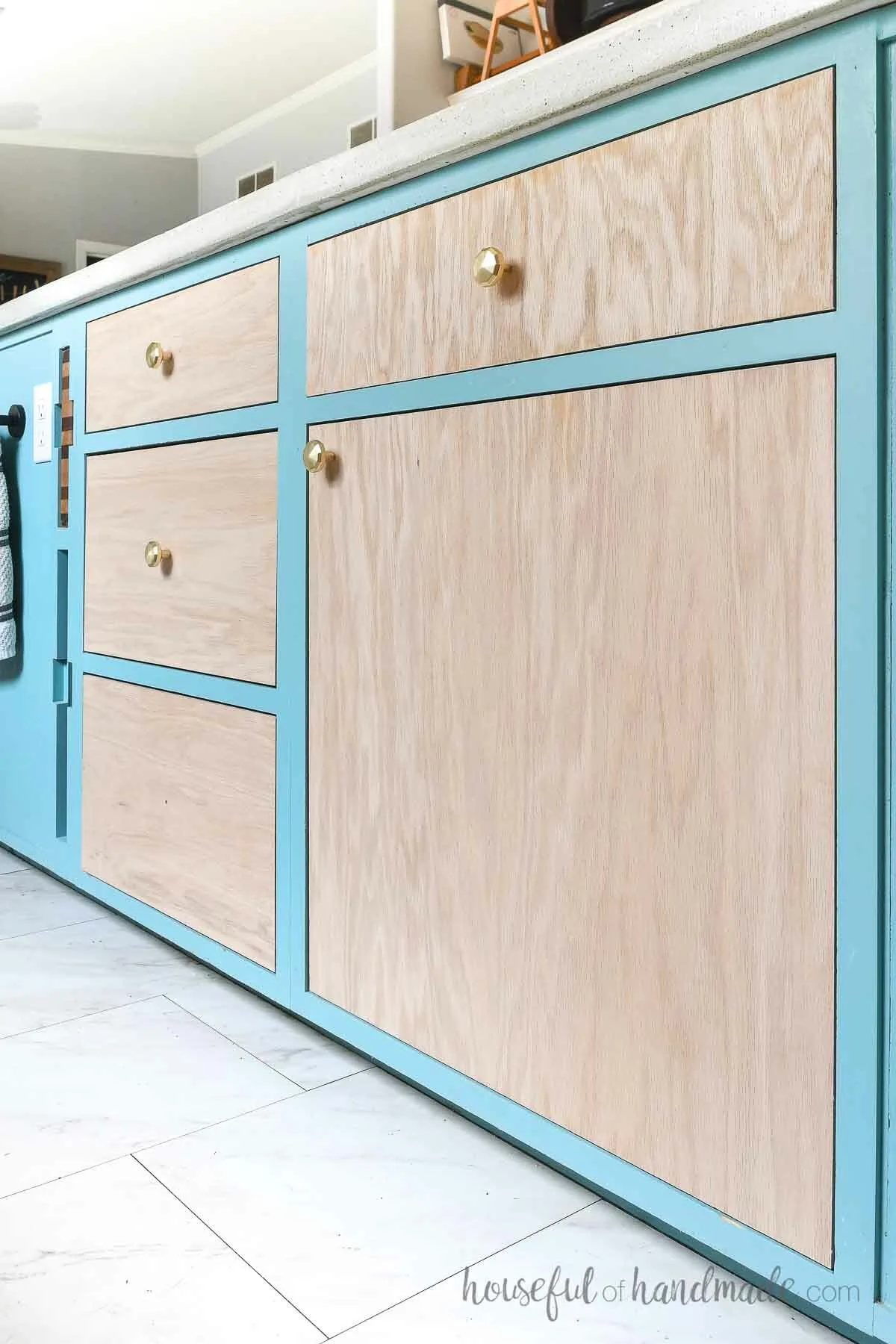 Teal painted kitchen island with inset plywood cabinet doors in oak.