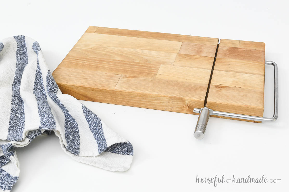 Homemade cheese slicer made from a scrap of butcher block.