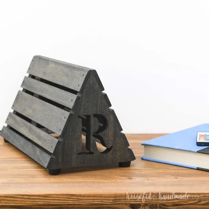 Black stained DIY book rest with initial cutout on the front.