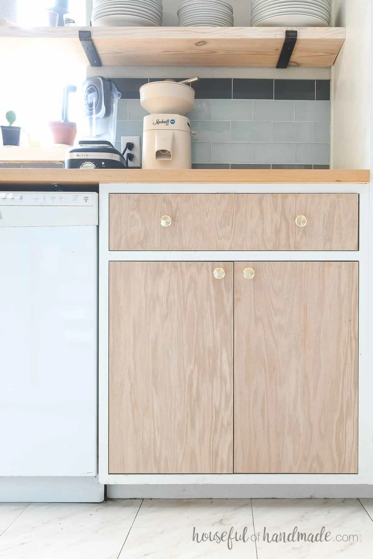 White cabinet frames with plywood door installed so it is inset with a drawer on top.