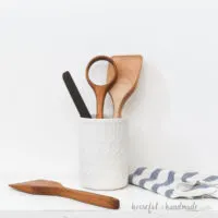 Four DIY wood cooking utensils in a white utensil holder.