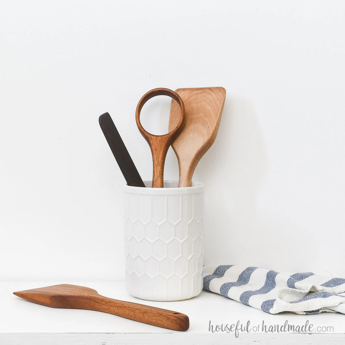 Four DIY wood cooking utensils in a white utensil holder.