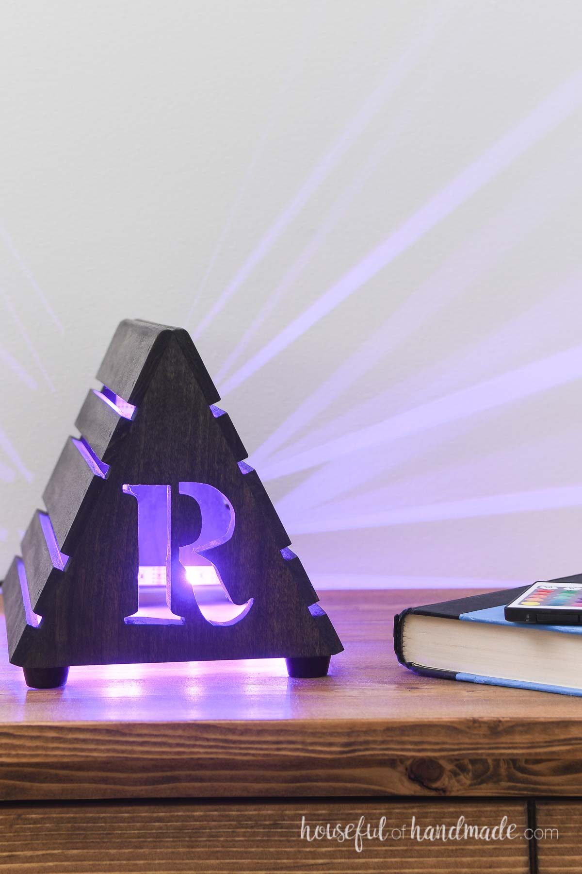 Purple lights glowing from the slats and cutout R on the nightlight book stand. 