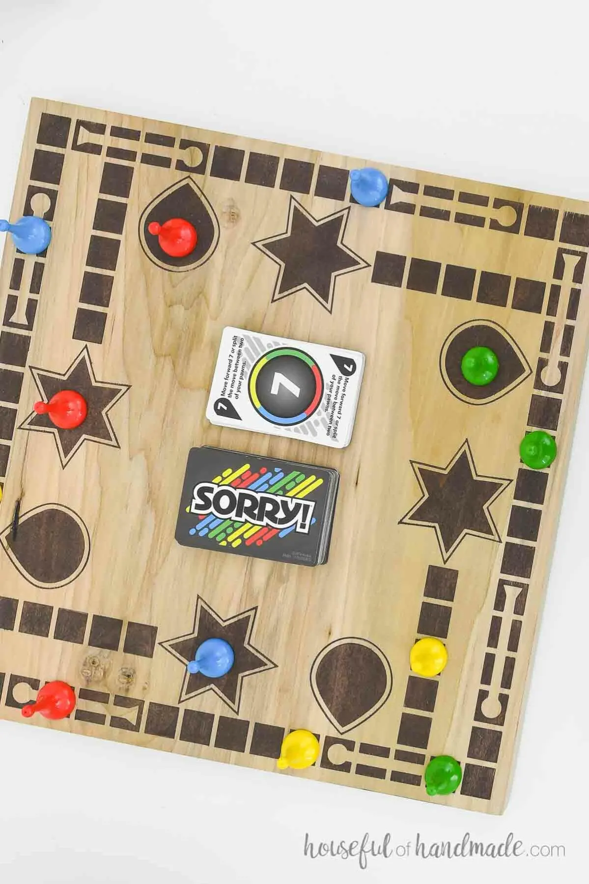 Top down view of the IDY wood game board with cards and piece on it. 