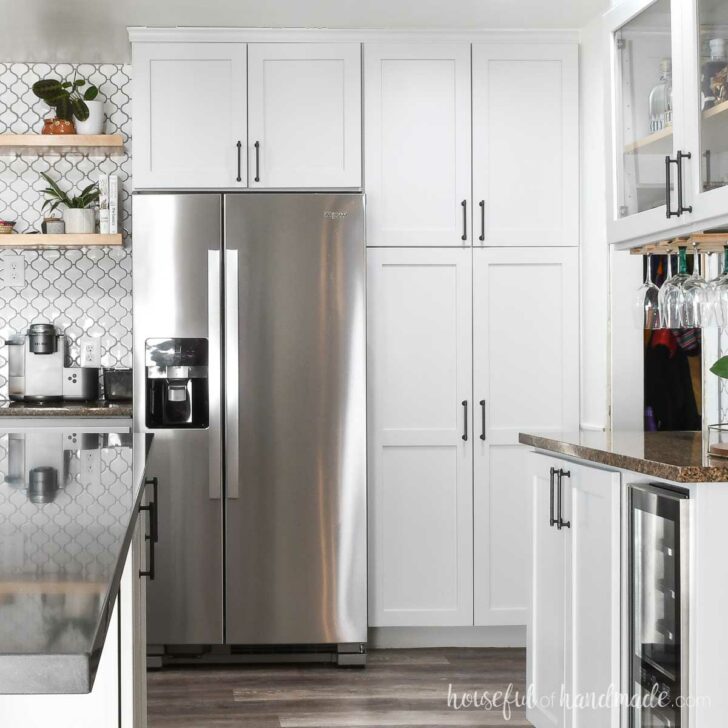 Gray painted DIY pantry cabinets around a stainless steel fridge.