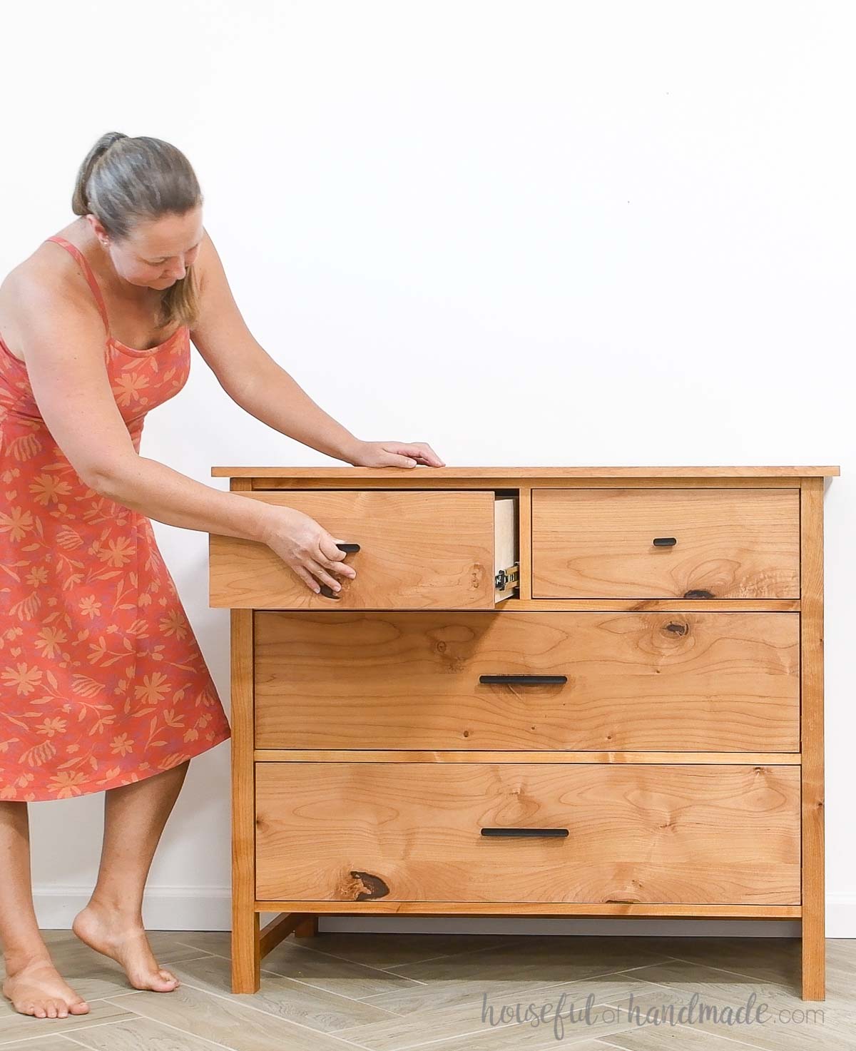 Kati opening one of the top drawers of the DIY 4 drawer dresser.