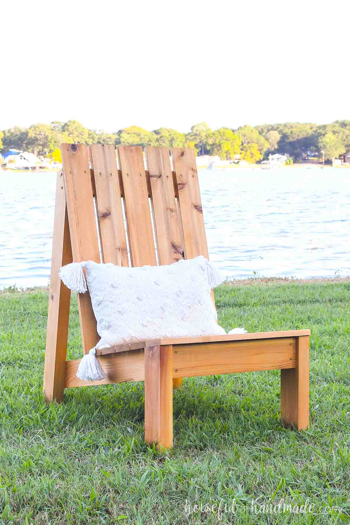 DIY cedar patio chair with white lumbar cushion with tassels.