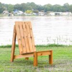 XL modern Adirondack chair made from cedar sitting on a lawn in front of a lake.
