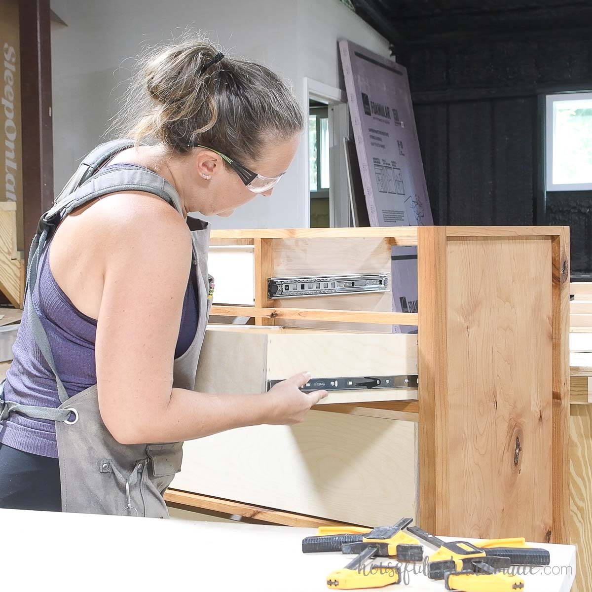 Sliding a drawer box into the dresser using drawer slides. 