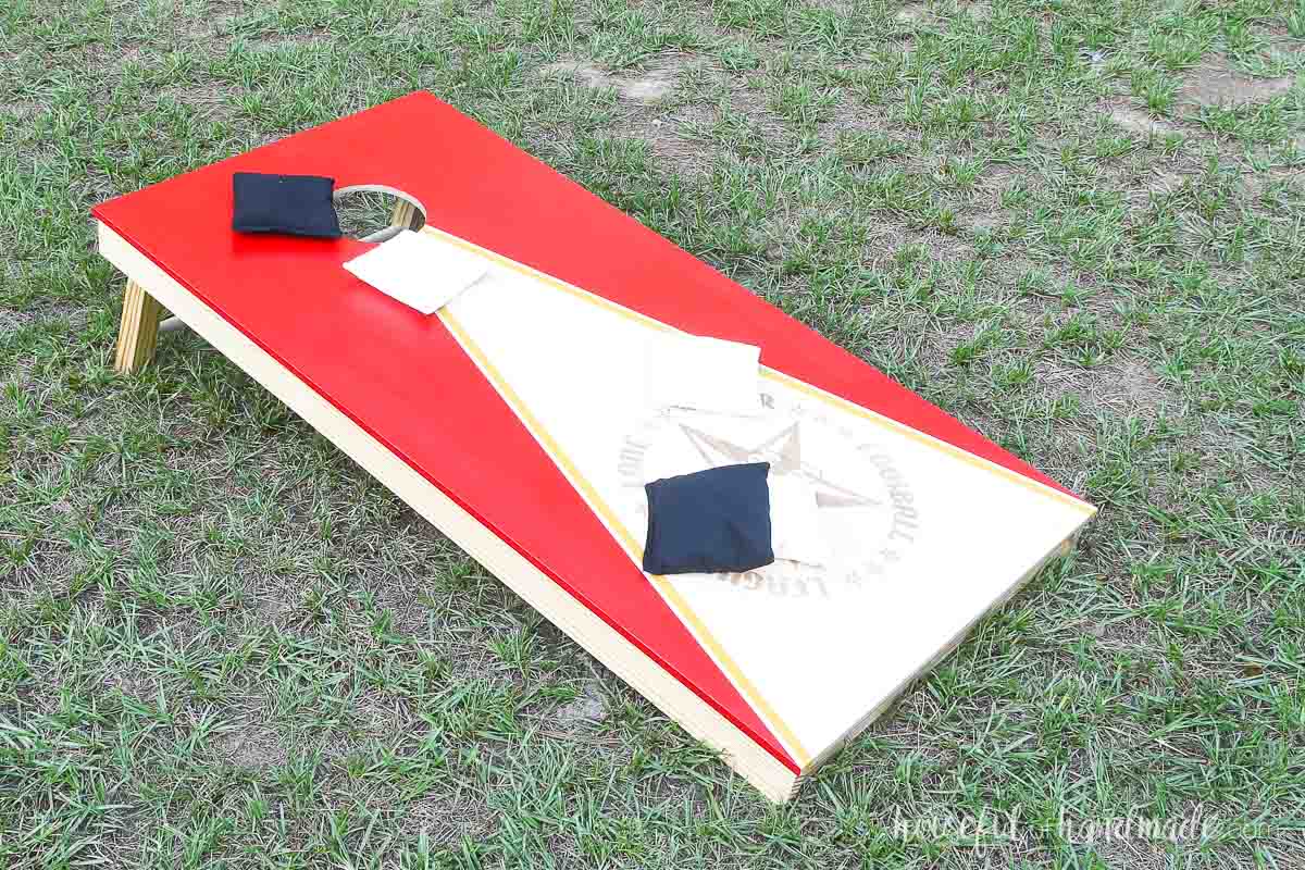 Cornhole board with V shaped red paint and logo lasered in the center. 