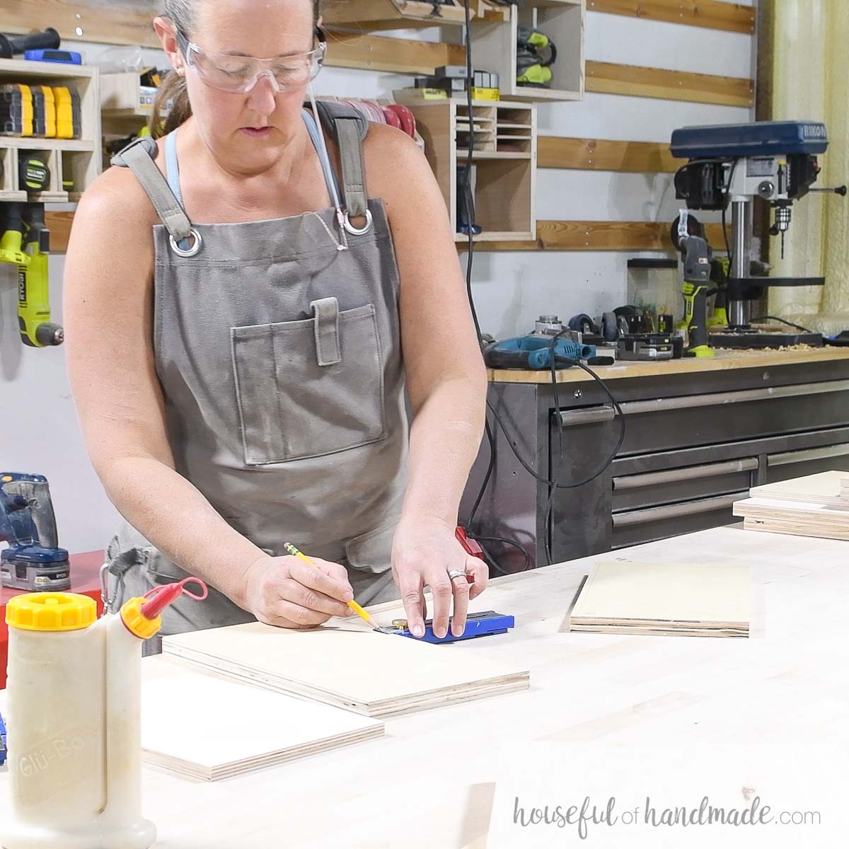 Drawing a line on the bottom of the plywood pieces. 