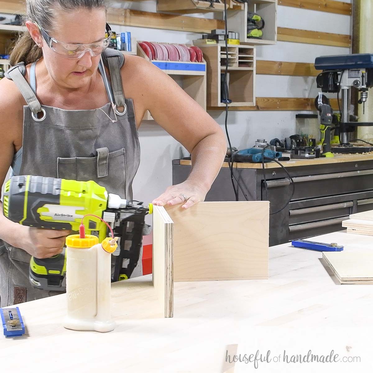 Nailing two pieces of plywood together with a pneumatic nailer. 