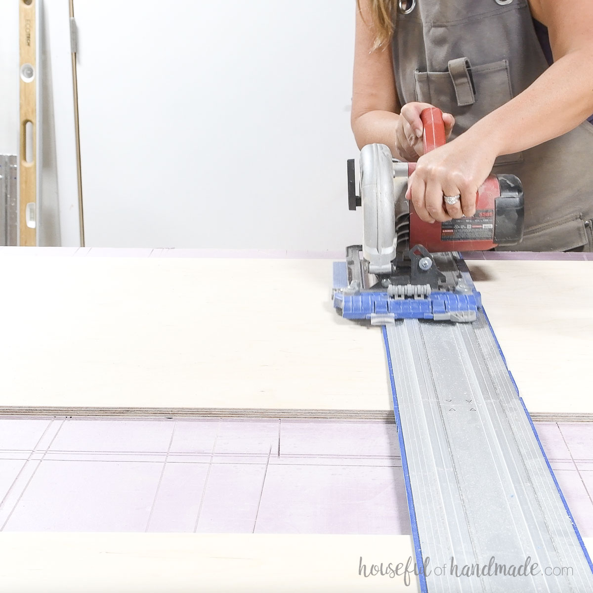 Cross cutting plywood with a circular saw and guide track. 