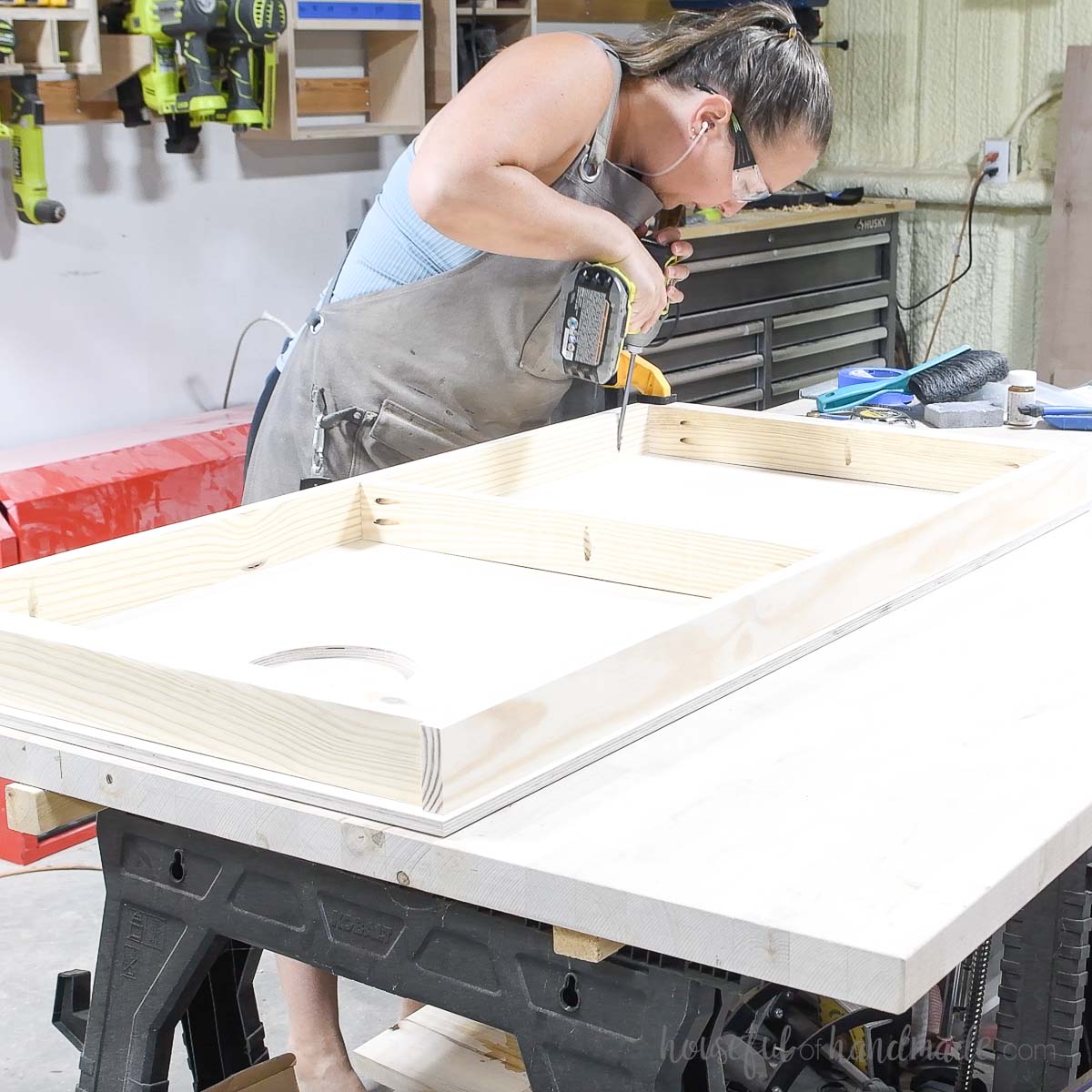 Attaching the top of the cornhole board to the frame. 