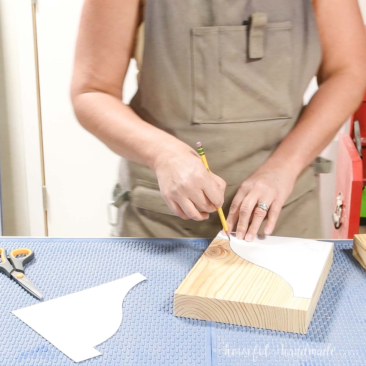 Tracing a paper corbel template onto the board. 