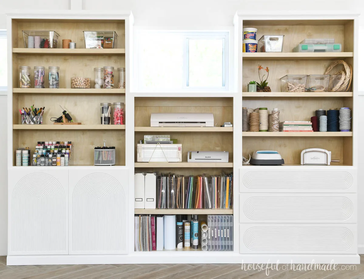 Two tall bookcases built in with a shorter one between them. 