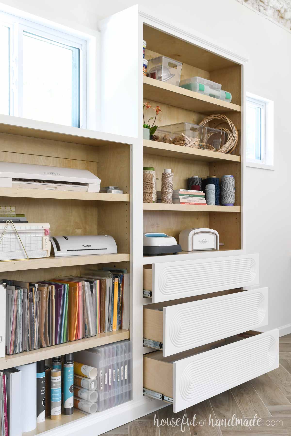 Built in cabinets with drawers on one side open showing the drawer boxes. 