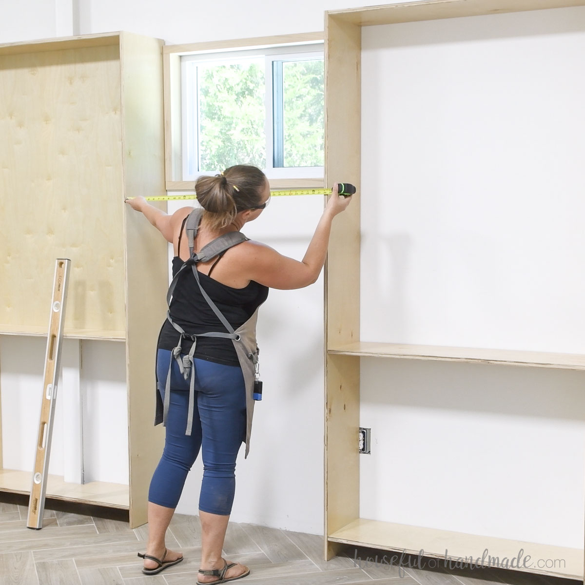 Measuring for the center bookcase between the assembled outer ones. 