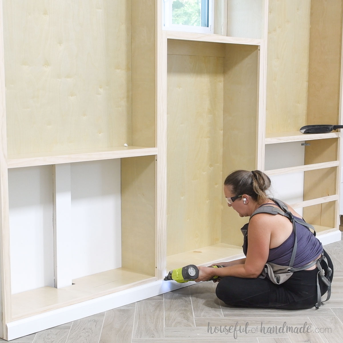 Attaching baseboards to the front of the built in bookcases. 