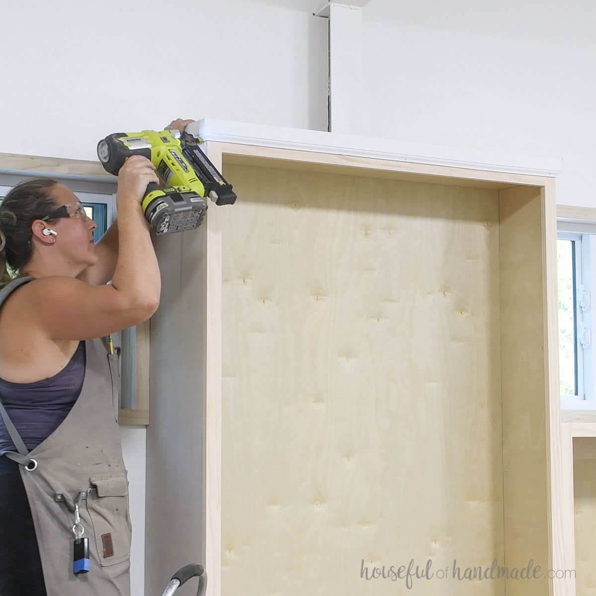 Attaching moulding to the top of the tall bookcases. 