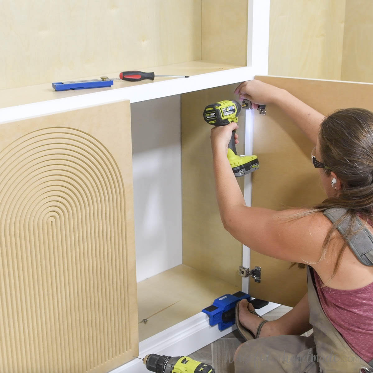 Attaching the doors to the cabinet face frame with overlay hinges. 